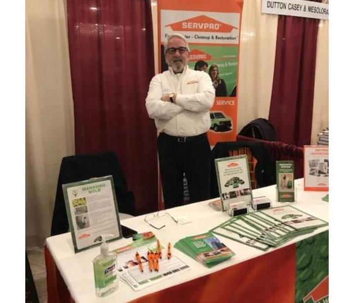 SERVPRO salesperson at a desk decorated with SERVPRO marketing material