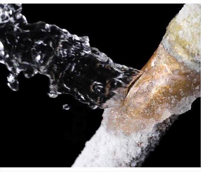A frozen copper pipe bursting with water