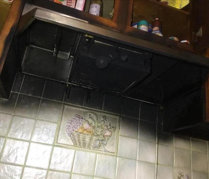 Kitchen hood that has been stained and damaged by fire and soot