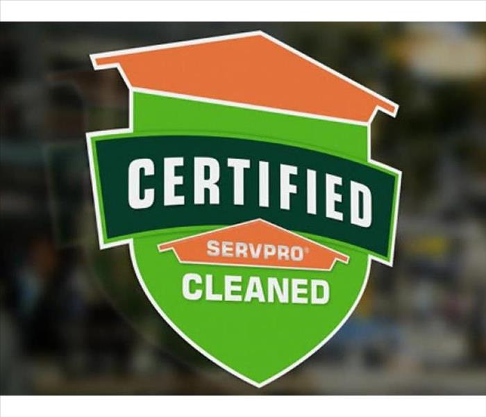 Green and orange window sticker saying "Certified: SERVPRO Cleaned"